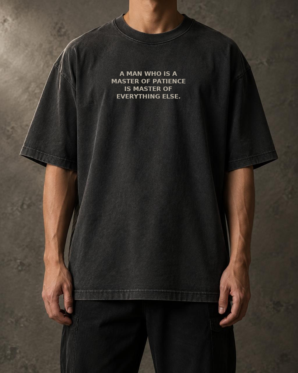 Washed black t-shirts front with the embroidered quote “A man who is a master of patience is master of everything else.”
